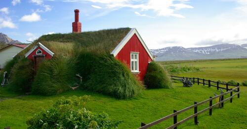 Красный дом заросший зеленым газоном