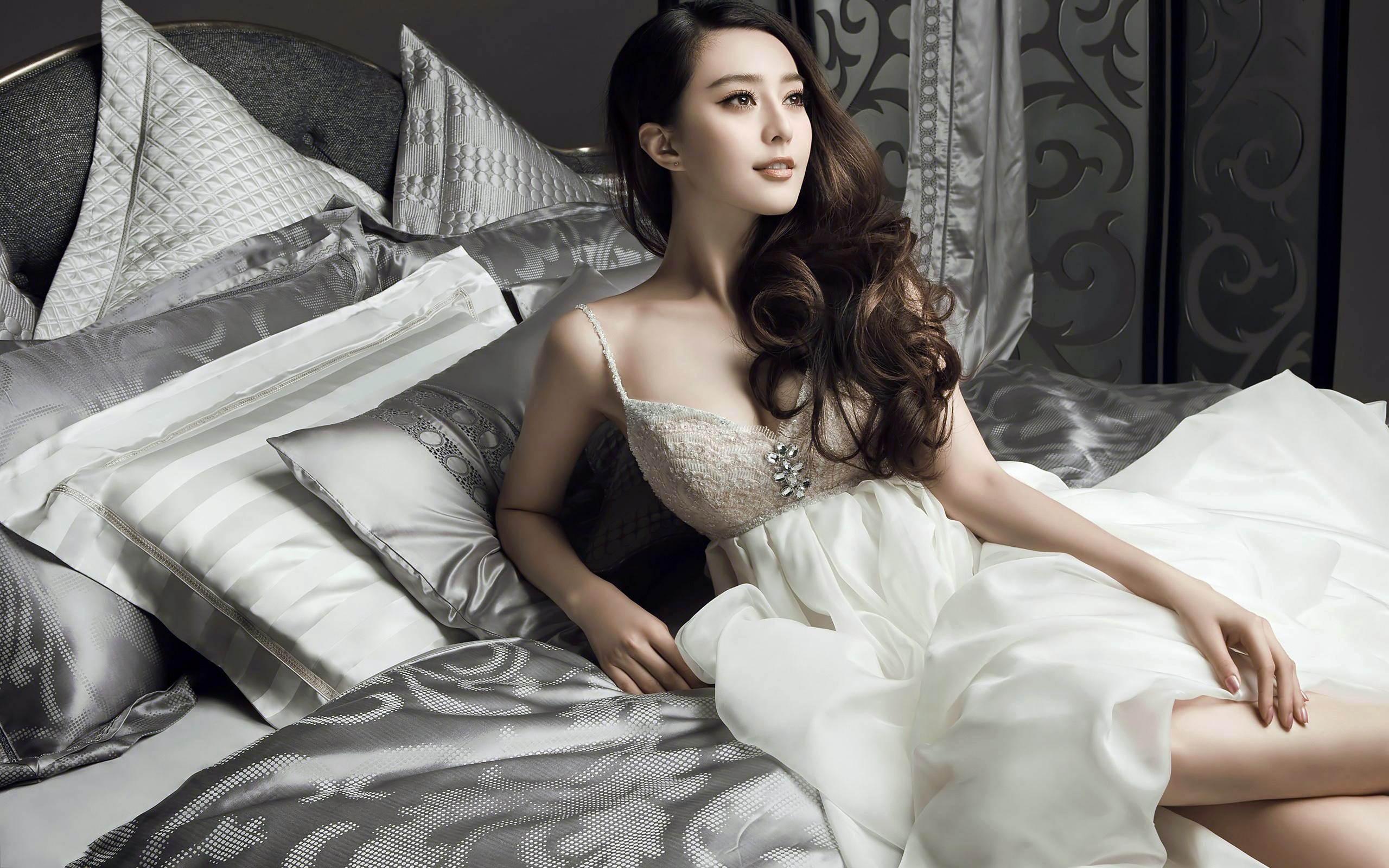 Фань Бинбин в белом платье лежит на кровати