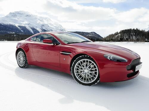 Red aston martin dbs in the snow.