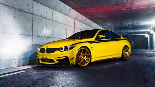 Yellow bmw m4 with a black stripe on the side