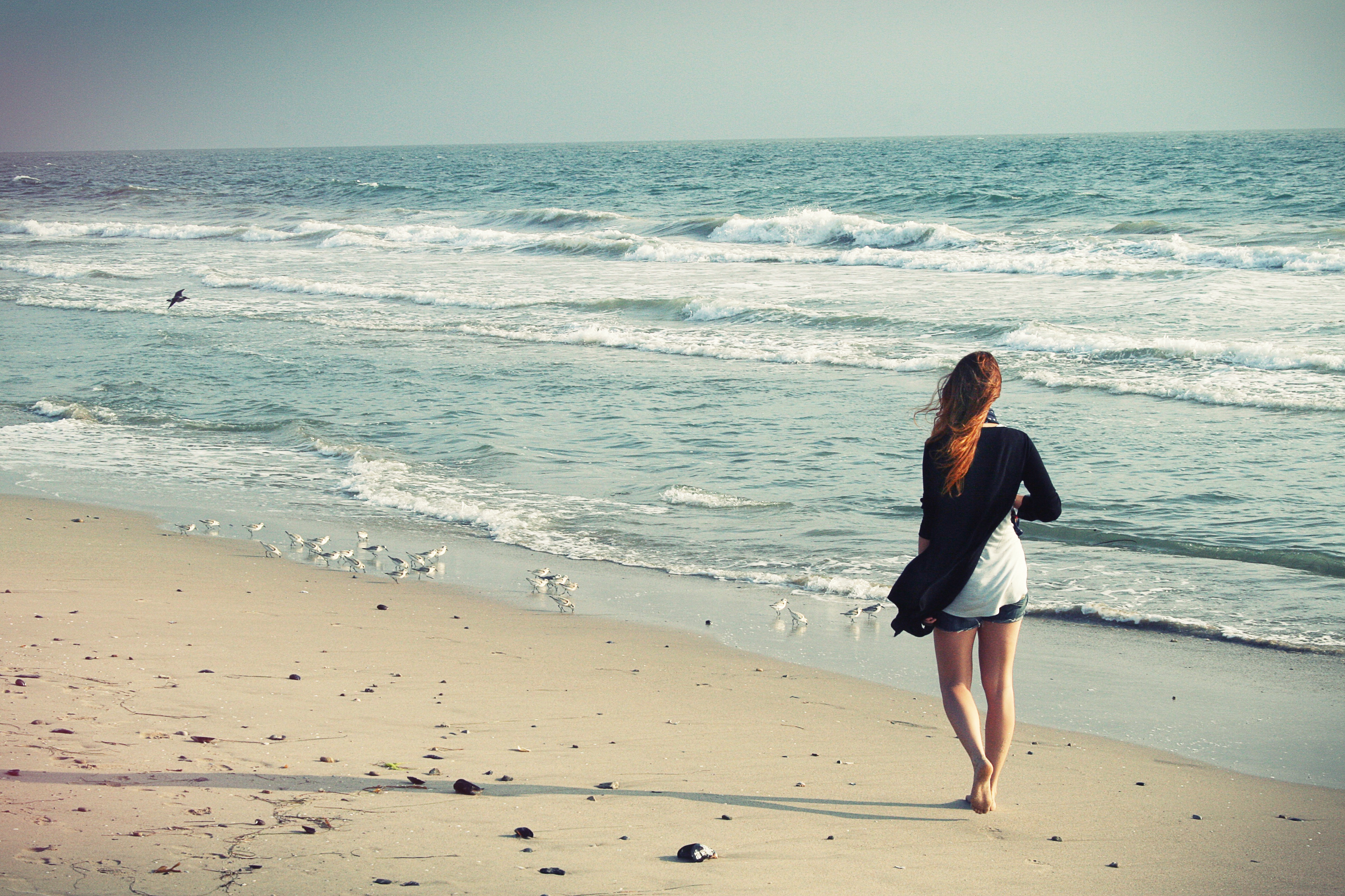 A girl walks on a sandy beach