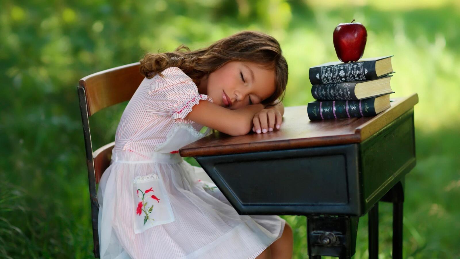 Бесплатное фото Девочка спит за рабочим столом