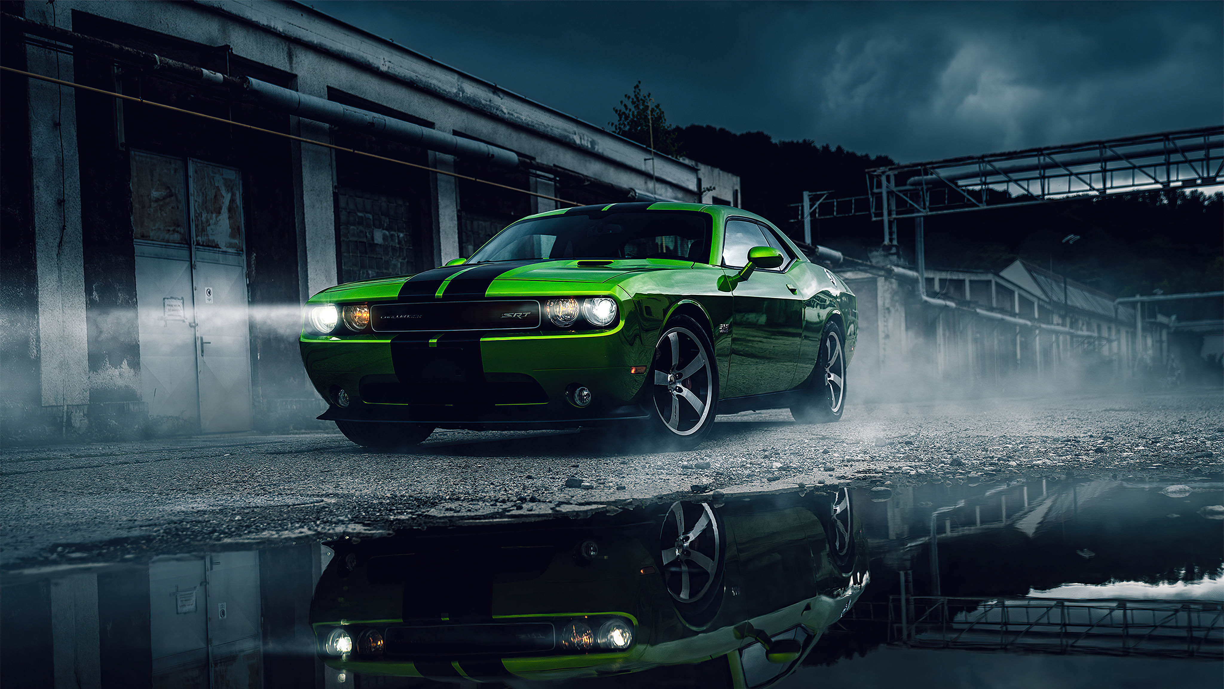 A green Dodge Challenger on a foggy evening.