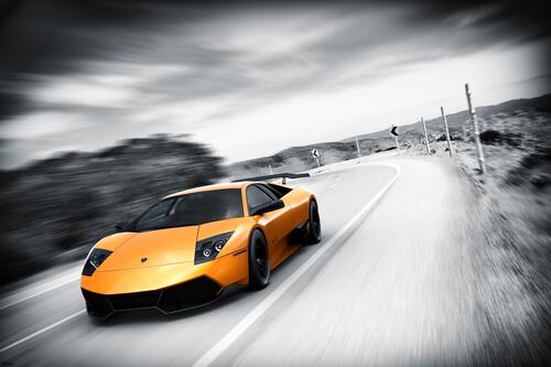Lamborghini murcielago оранжевого цвета едет по трассе