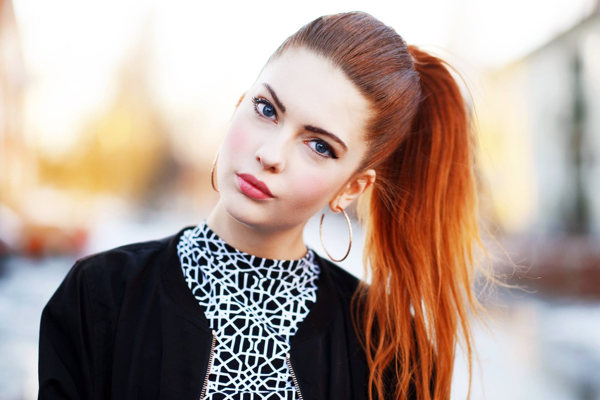 Free photo Portrait of a red-haired girl with a ponytail in sunny weather