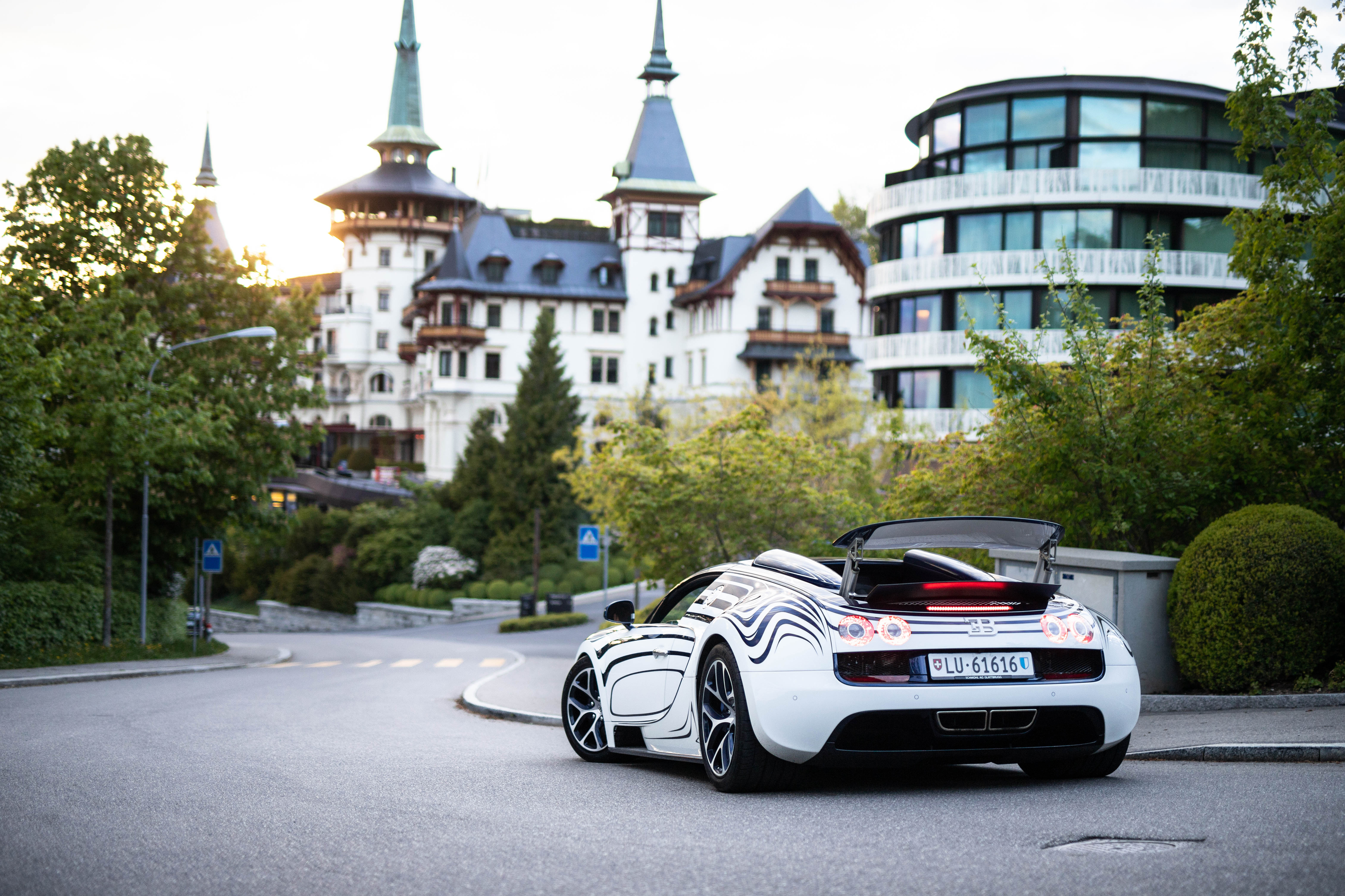 A picture of a white Bugatti Veyron against a city backdrop