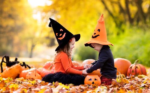 Две девочки играют в шапках хэллоуин