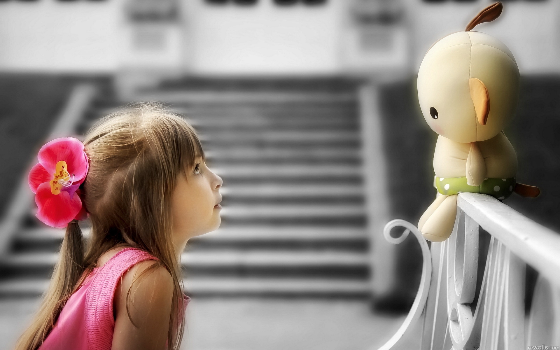 免费照片一个小女孩看着一个软玩具