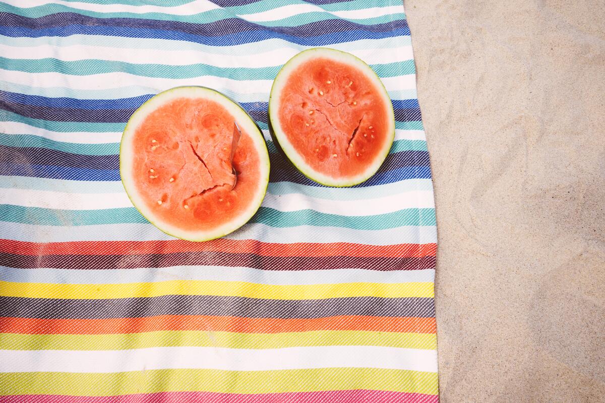 A watermelon in a popolam lay on a colored towel