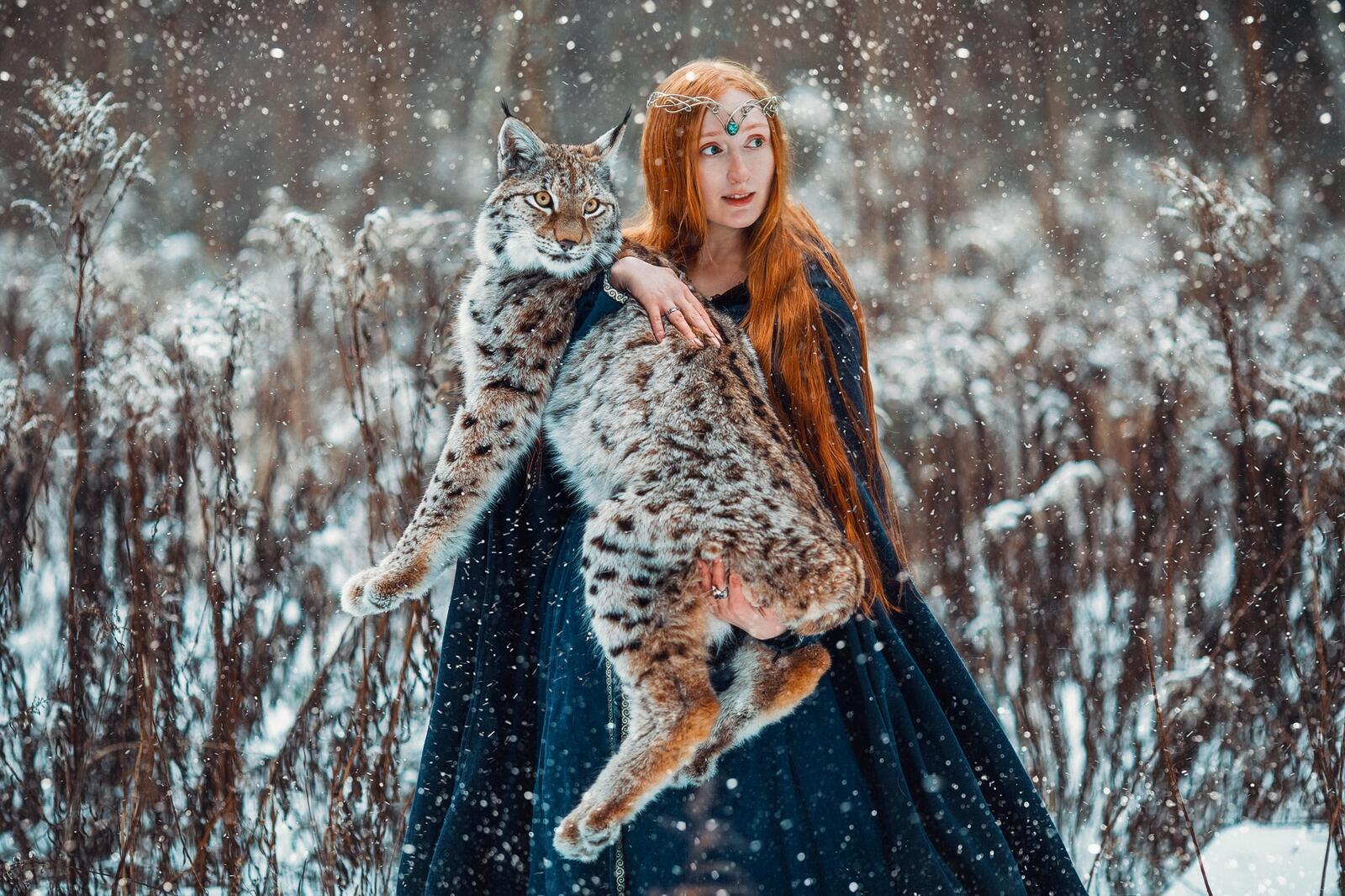 Бесплатное фото Рыжеволосая девушка держит в руках рысь