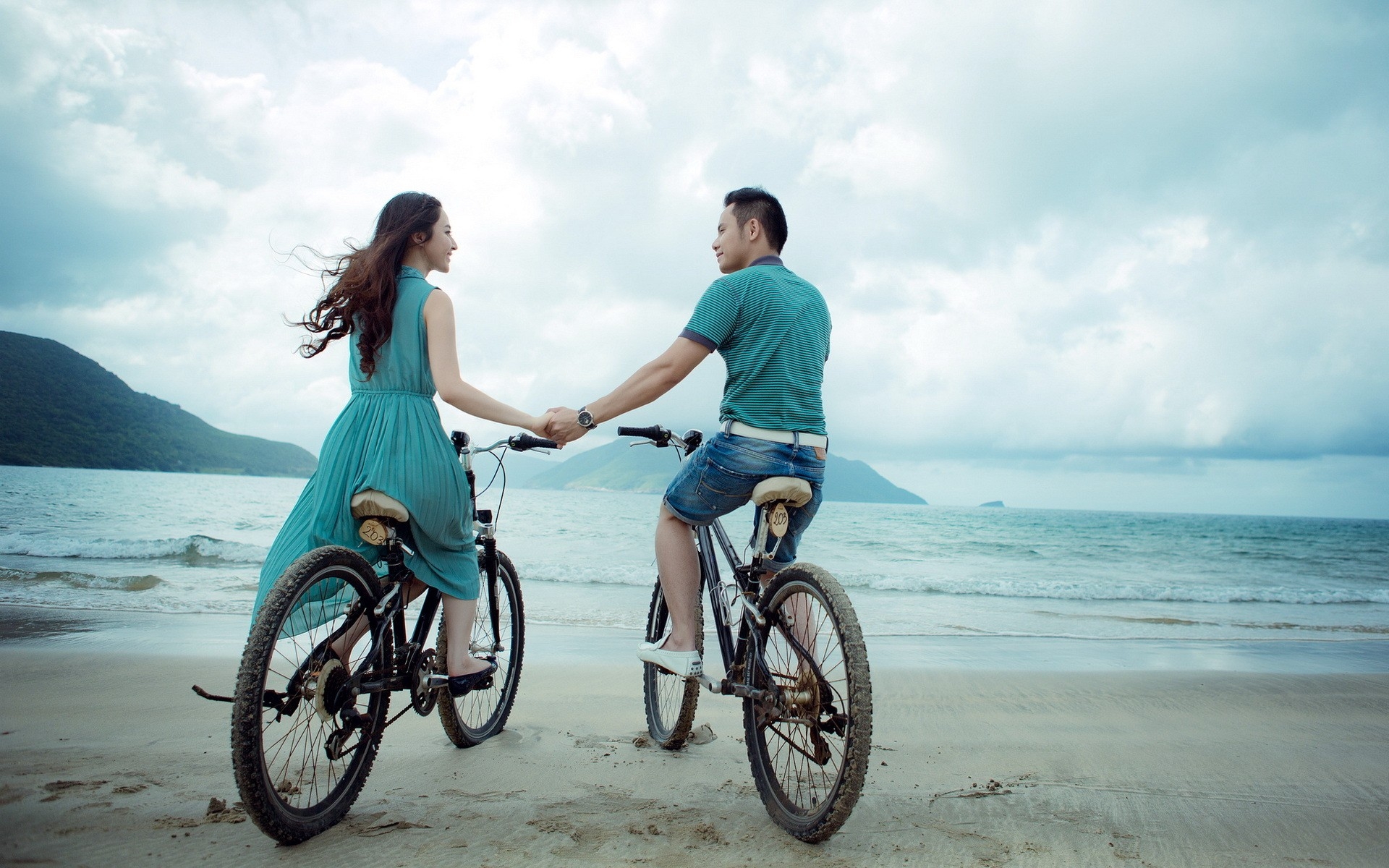 一对夫妇在海边骑自行车
