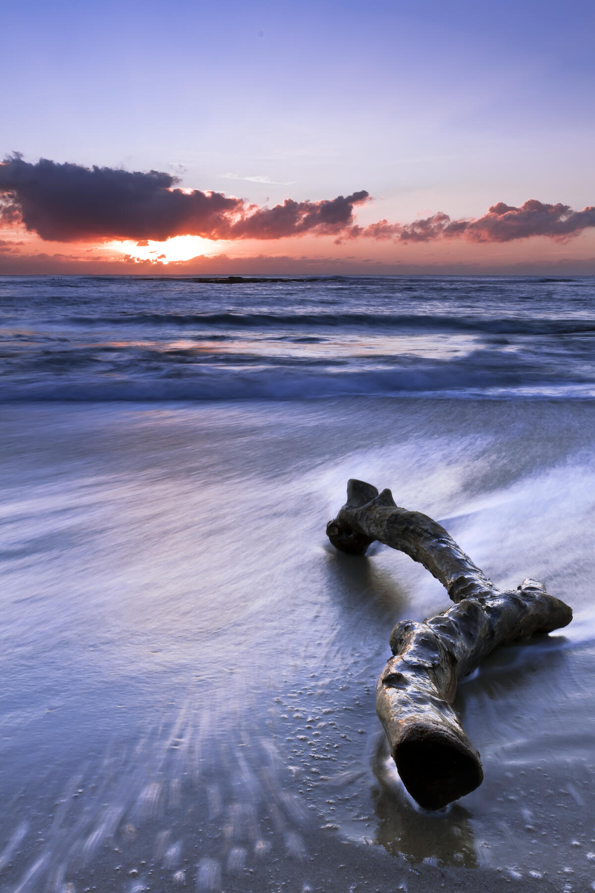 Палка лежит на берегу моря на закате