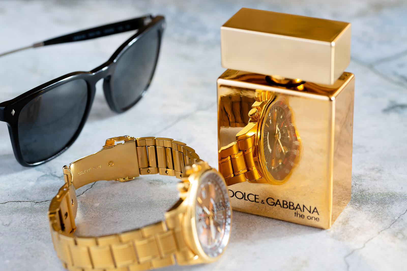 Free photo Watch and bottle of Dolce & Gabbana men`s perfume