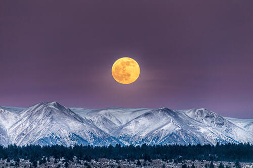 The yellow moon over the snowy mountains