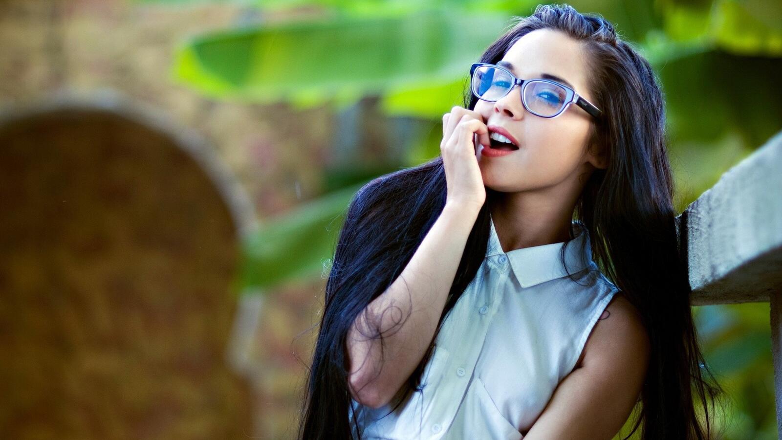 Free photo A young girl in a white blouse and vision glasses