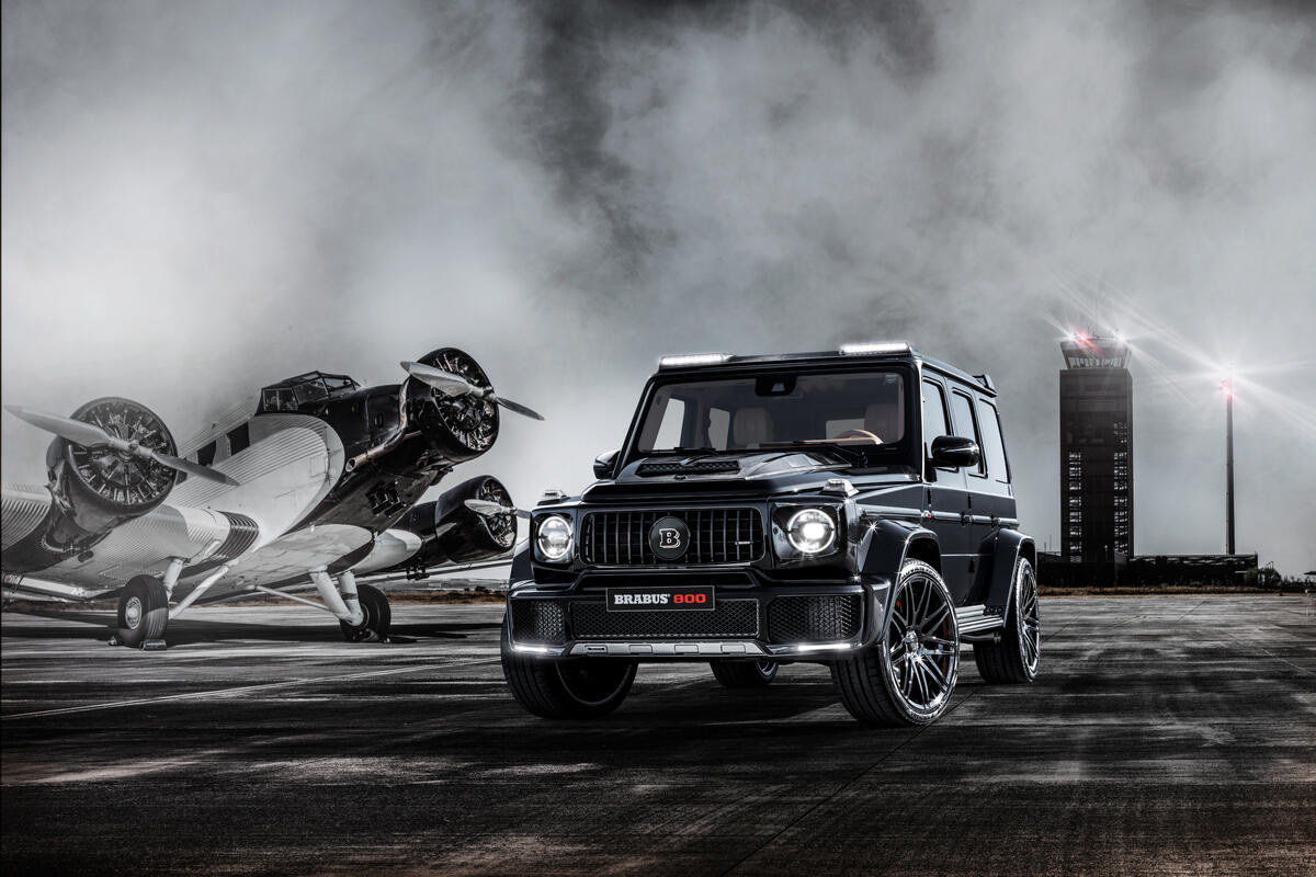 Mercedes Benz g class and an airplane in a monochrome photo