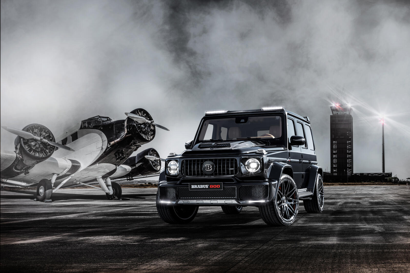 Free photo Mercedes Benz g class and an airplane in a monochrome photo