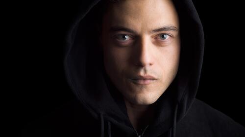 Rami Malek in a black hooded sweatshirt.
