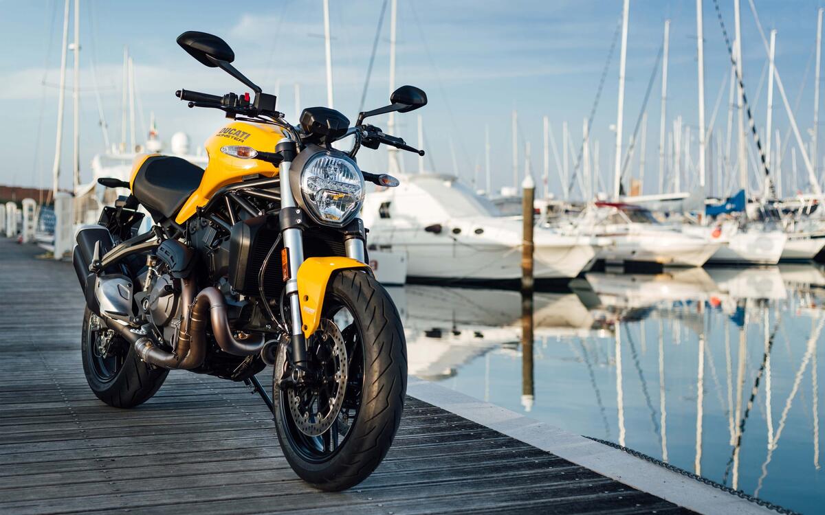 Ducati monster 821 in yellow stands on a bridge by the water