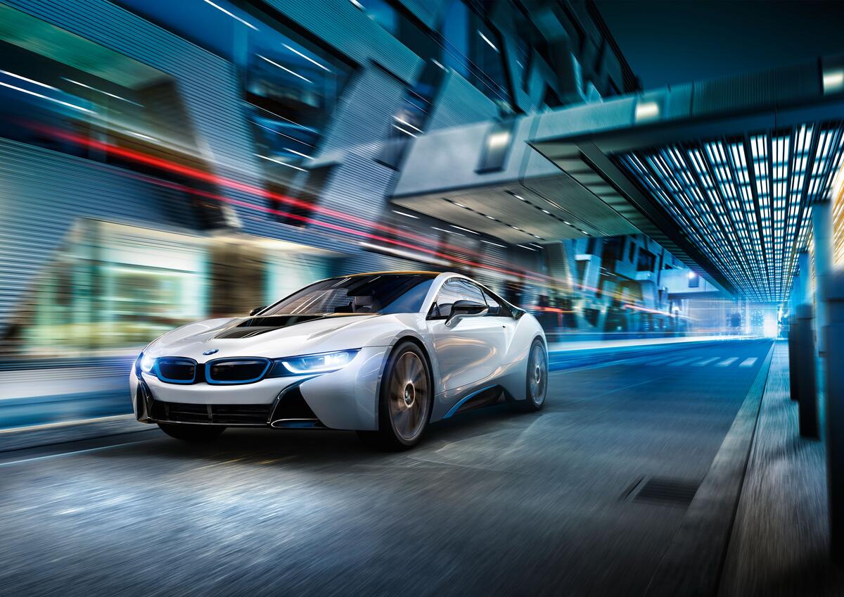 A picture of a BMW i8 driving over a bridge.