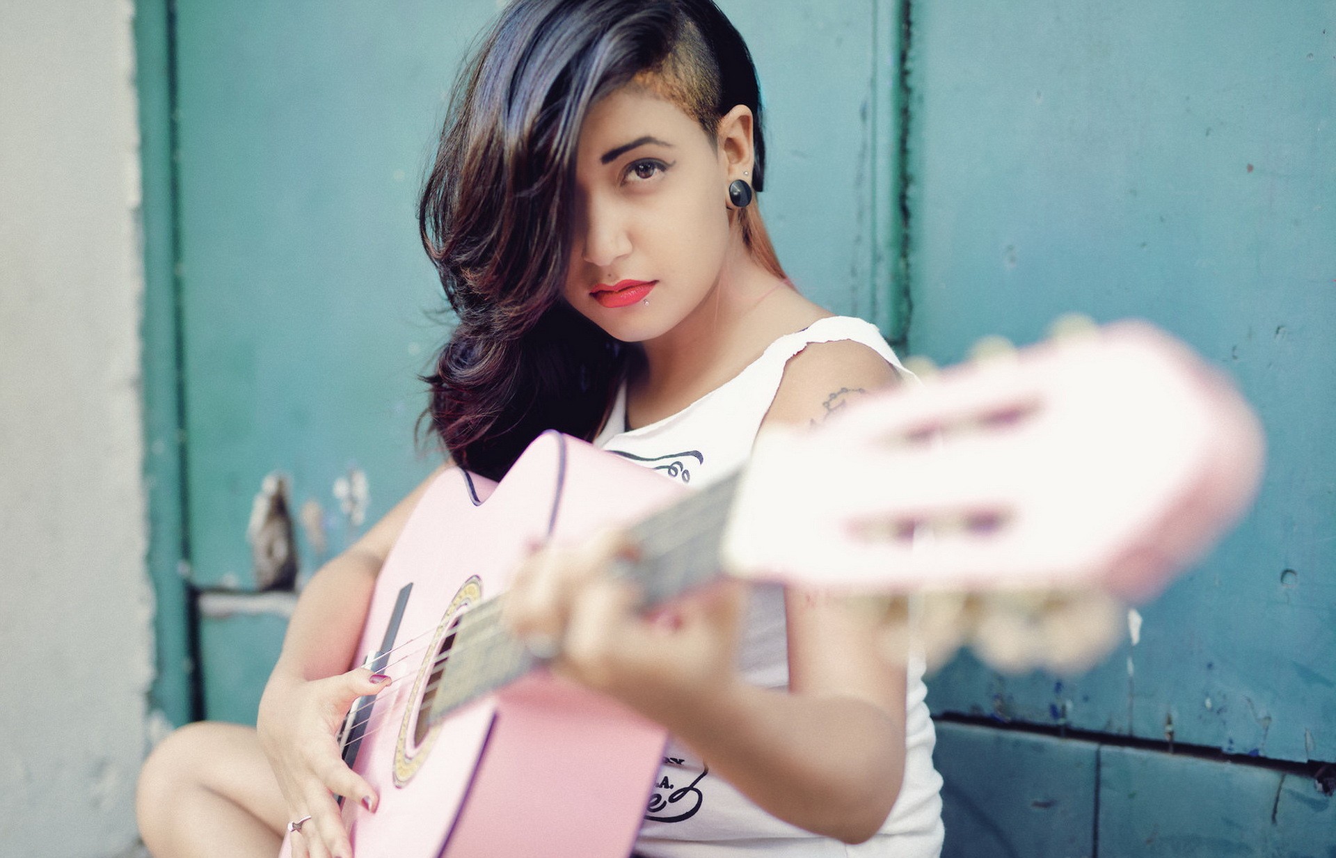 Бесплатное фото Молодая брюнетка с розовой гитарой