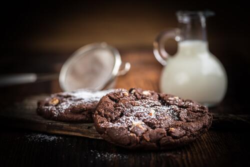 Chocolate cookies with powdered sugar and milk