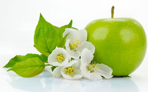 Зеленое яблоко с белыми маленькими цветочками