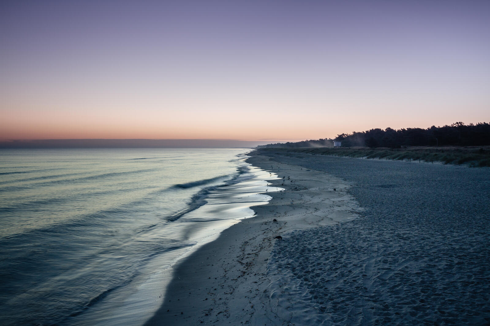 Бесплатное фото Береговая линия с белым песком на закате