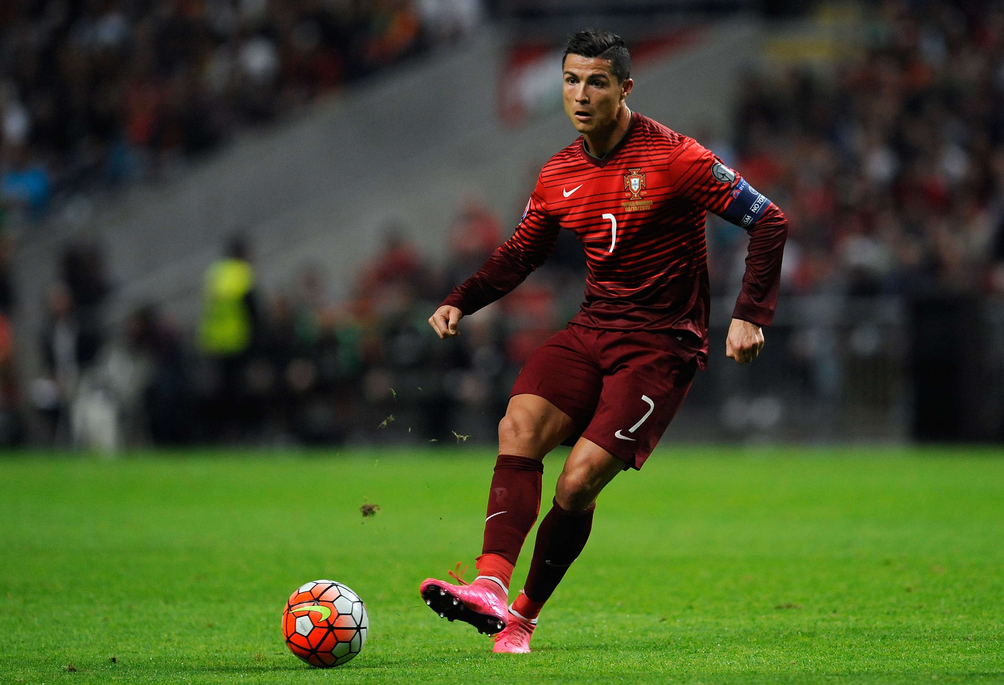 Кристиано Роналдо в красном костюме на футбольном поле
