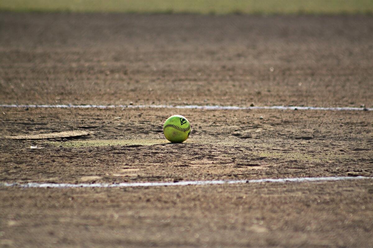 A baseball lies on a trampled field