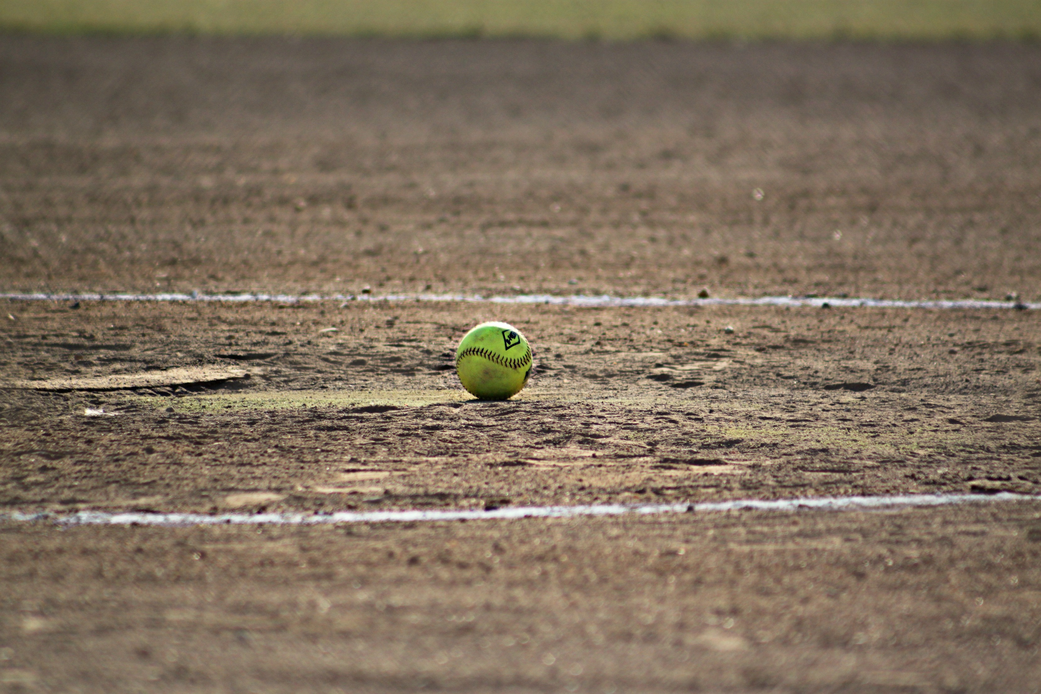 Бесплатное фото Бейсбольный мяч лежит на вытоптанном поле