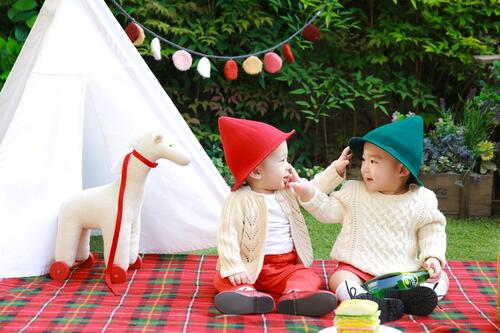 Two Asian twins dressed in gnome costumes