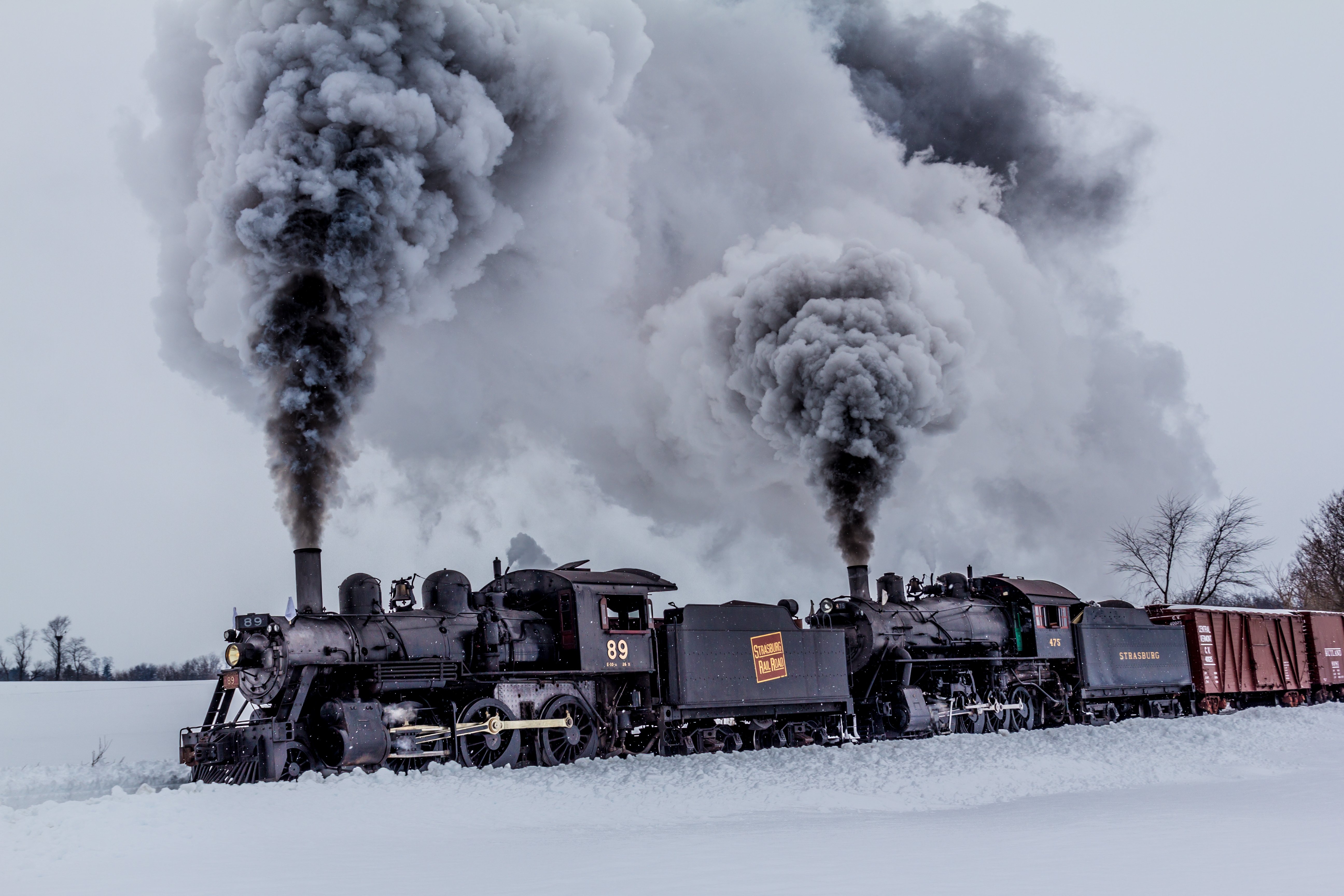 Free photo A steam locomotive driving through a snowy field