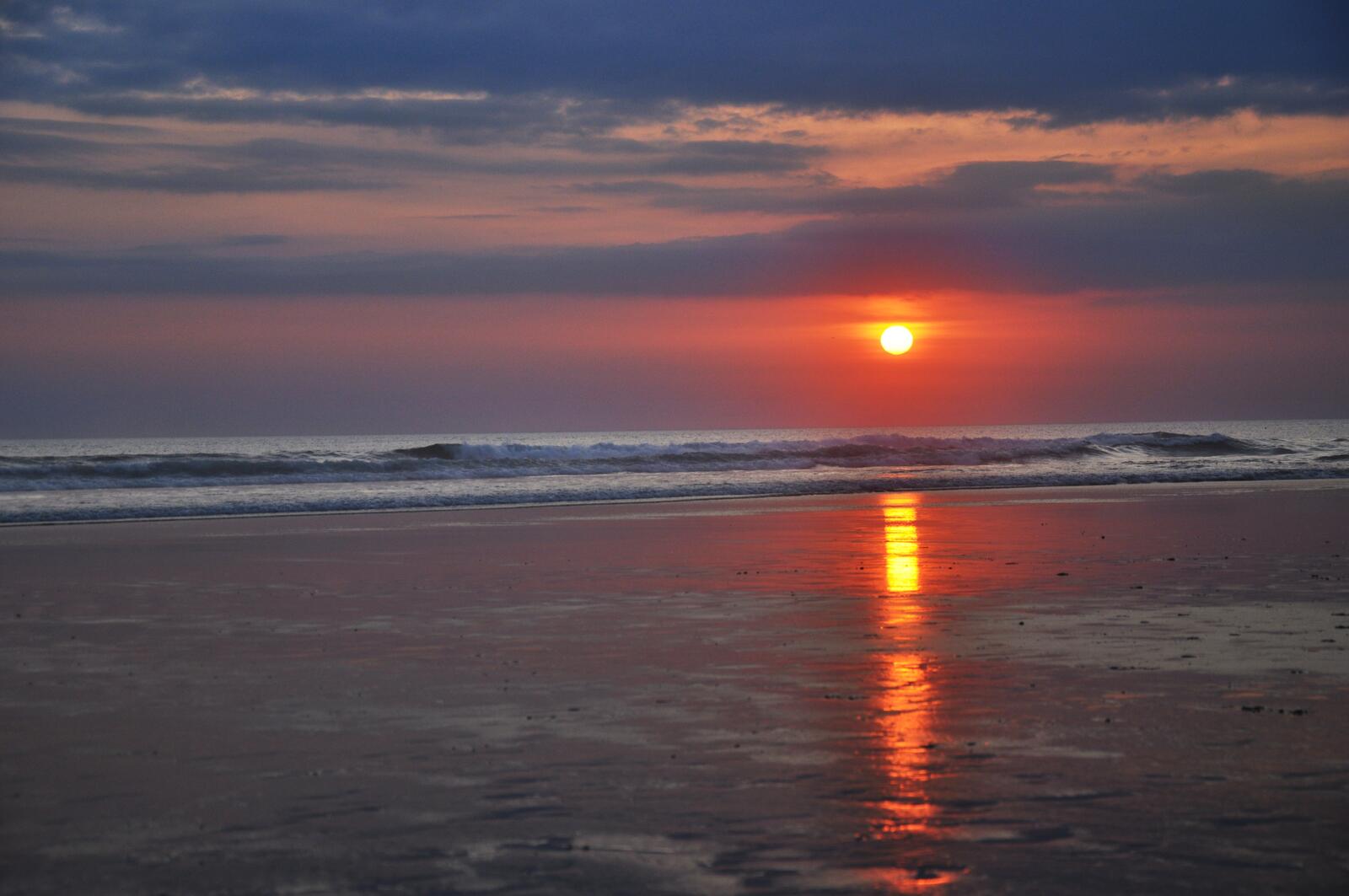 Бесплатное фото Красное солнце виднеется на горизонте моря