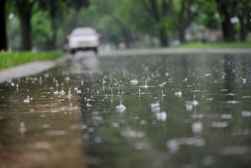 Raindrops fall into a deep puddle