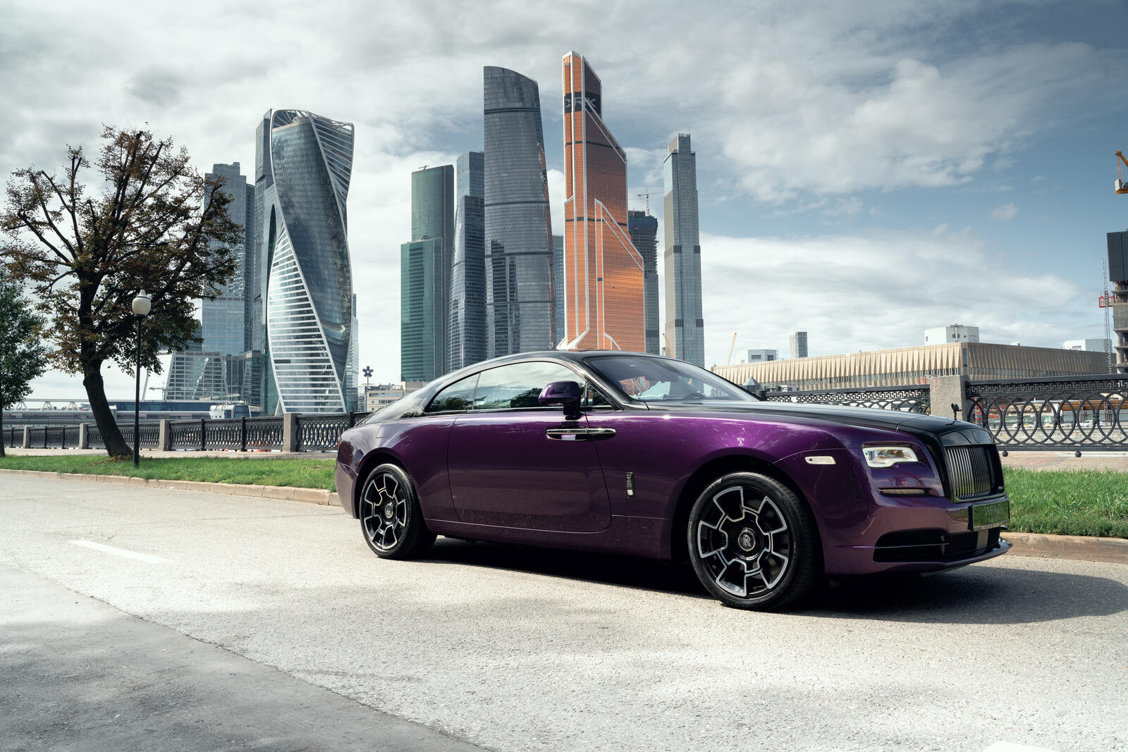 Бесплатное фото Фиолетовый Rolls Royce Wraith на фоне москва сити