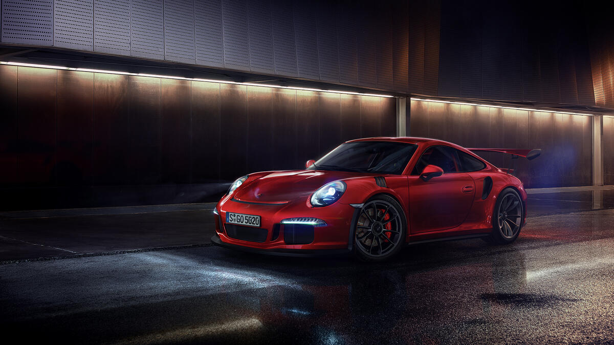 A red Porsche GT3 in the dark.