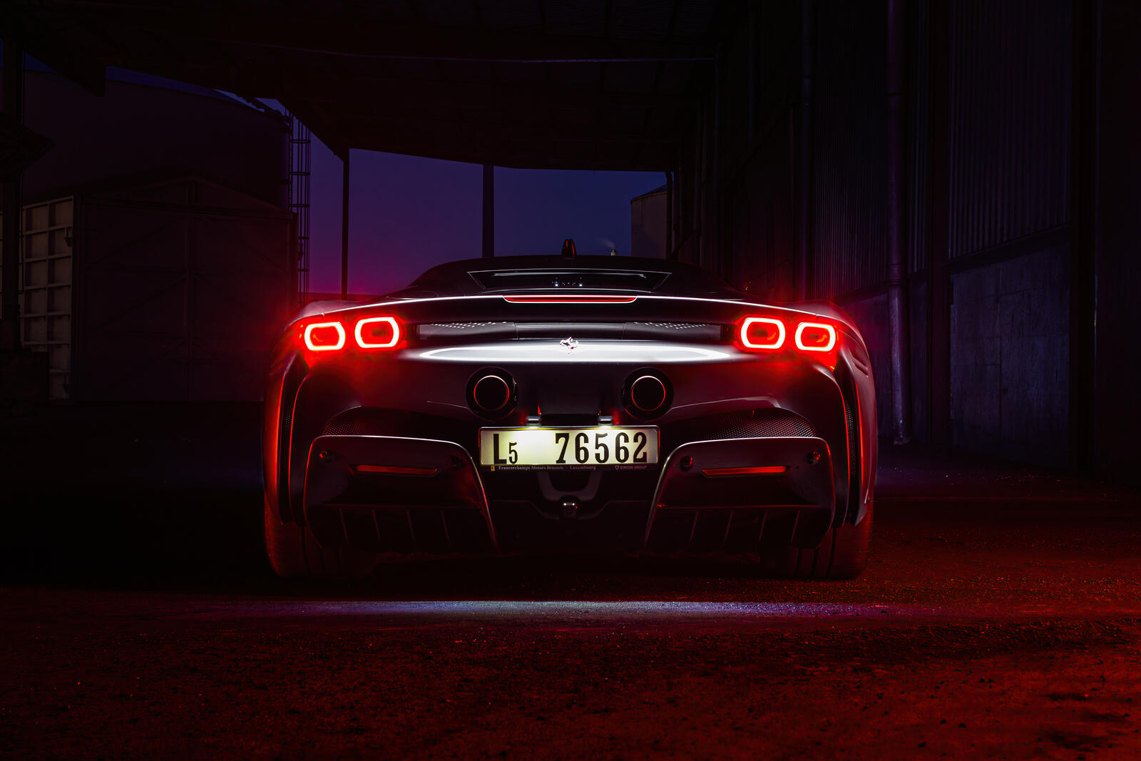 Free photo Rear of the ferrari sf90 stradale with lights on