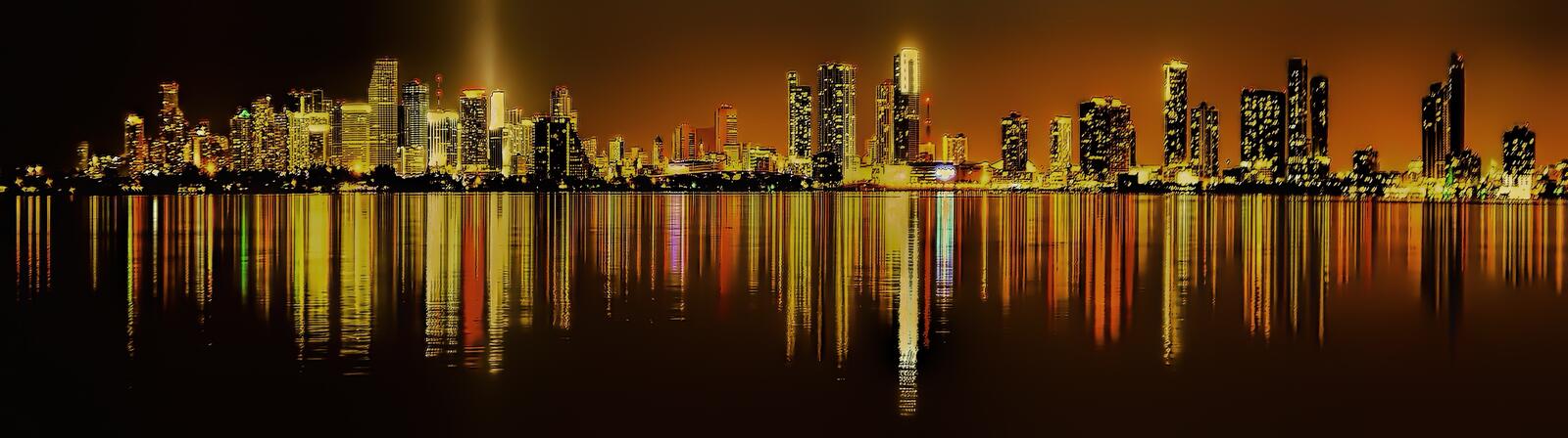 Бесплатное фото Ночной город с небоскребами отражается в воде