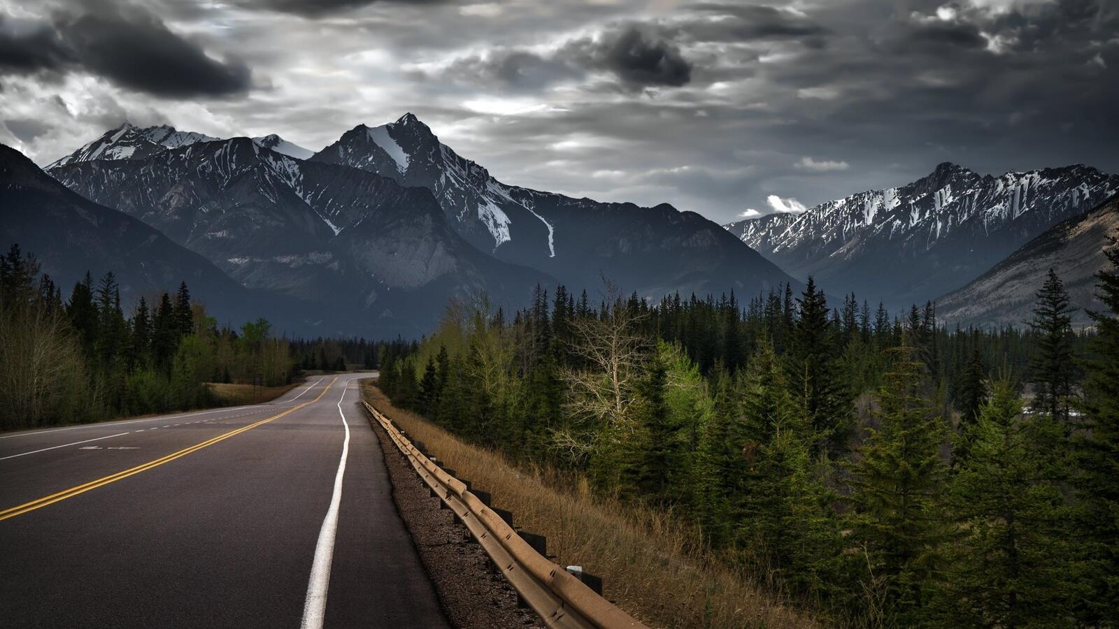 Wallpapers long road mountains dark clouds on the desktop