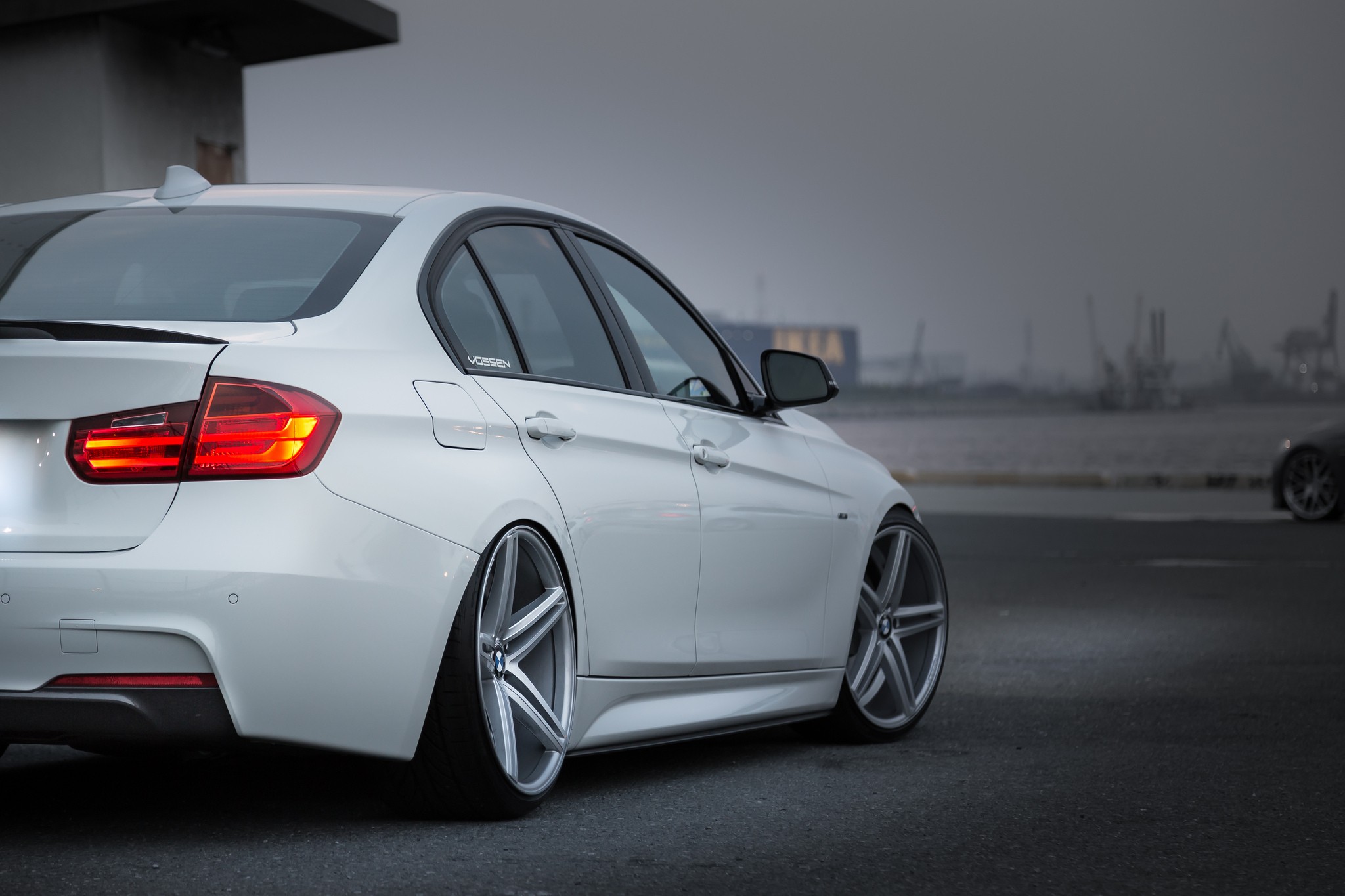 Белая BMW M3 на красивых больших дисках сфотографированная сзади