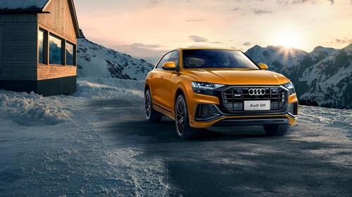 Audi q8 against the backdrop of snowy mountains