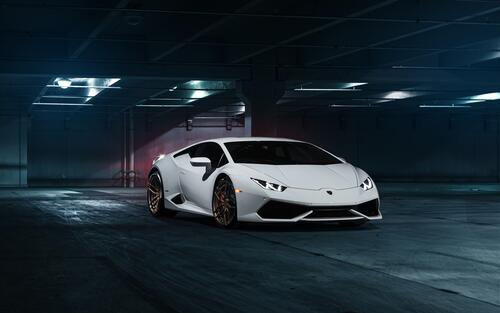 A white Lamborghini Huracan in an underground parking lot.
