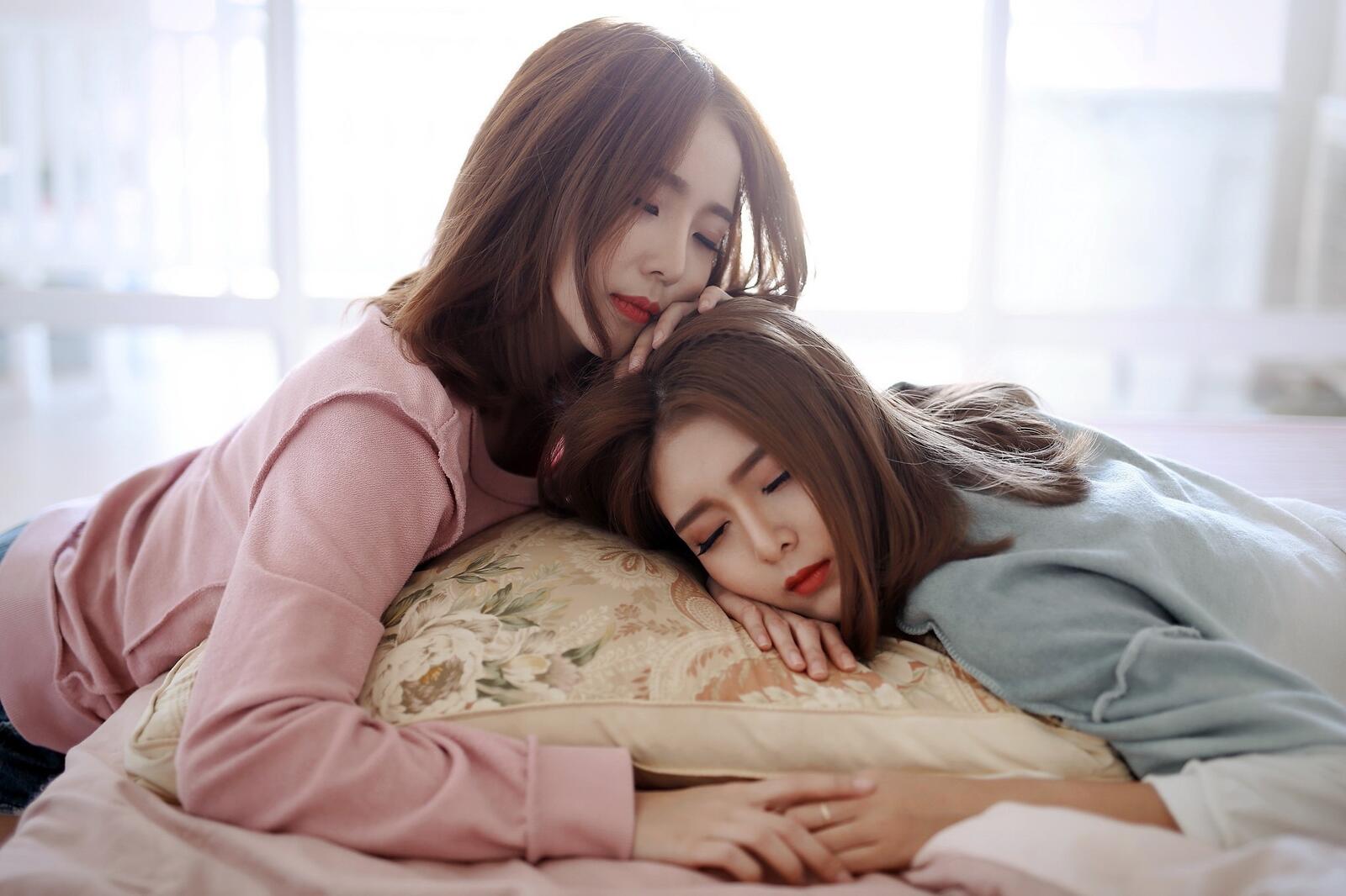 Free photo Two Asian girls sleeping on the same pillow
