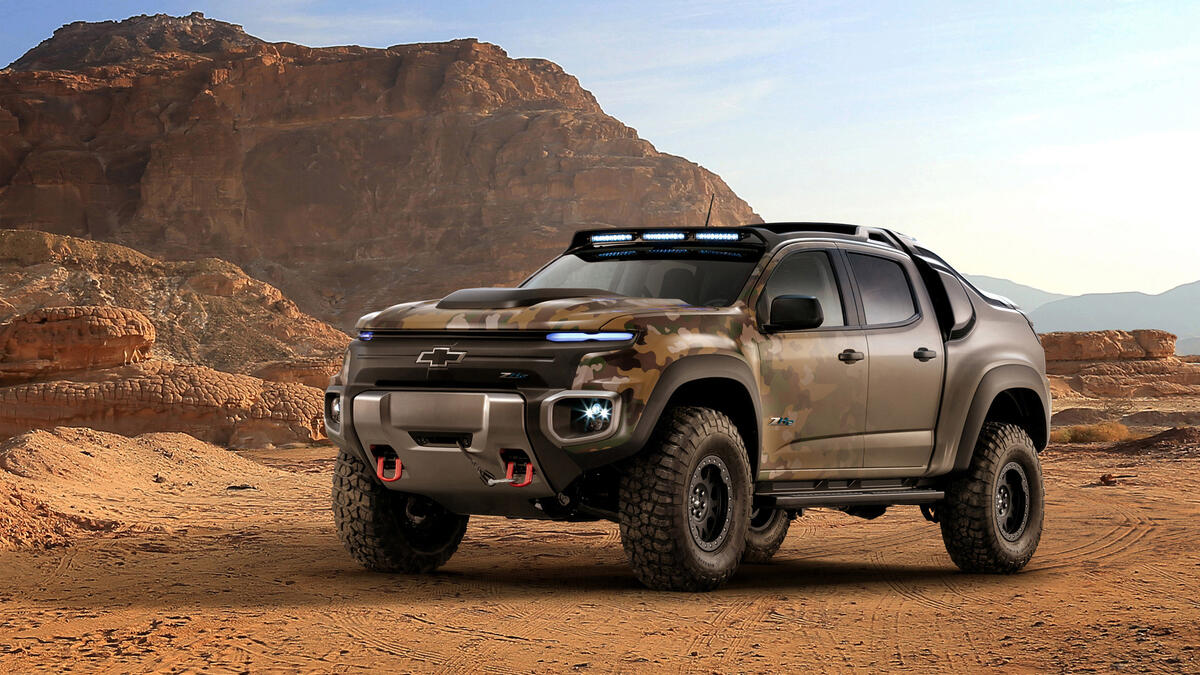 A camouflaged 2016 Chevrolet pickup truck in a sand pit