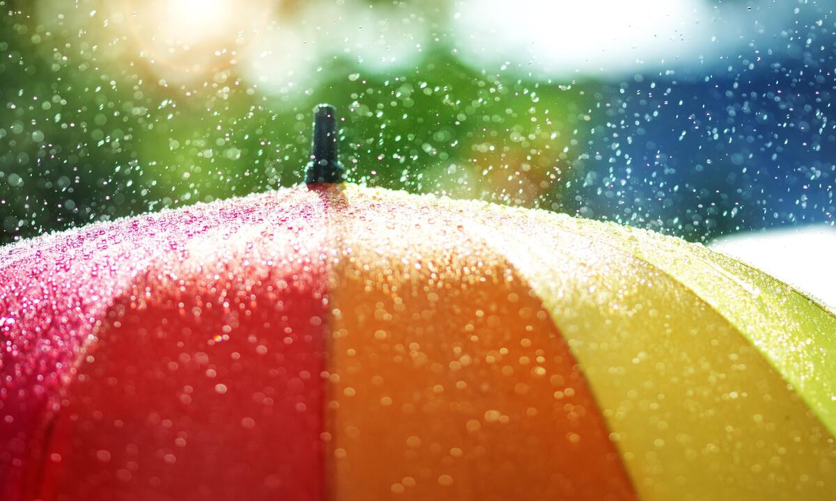 Raindrops fall on a colorful umbrella