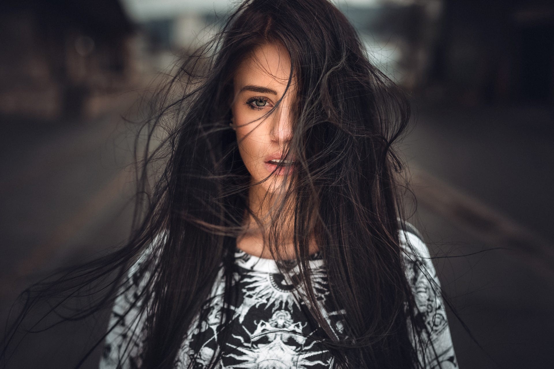 Портрет черноволосой девушки с волосами на лице