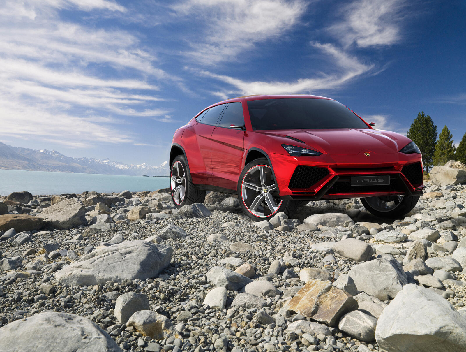 Free photo The red Lamborghini Urus drives over sharp rocks.