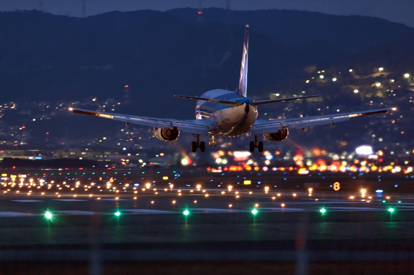Free photo An airplane lands on the night runway