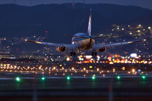 An airplane lands on the night runway